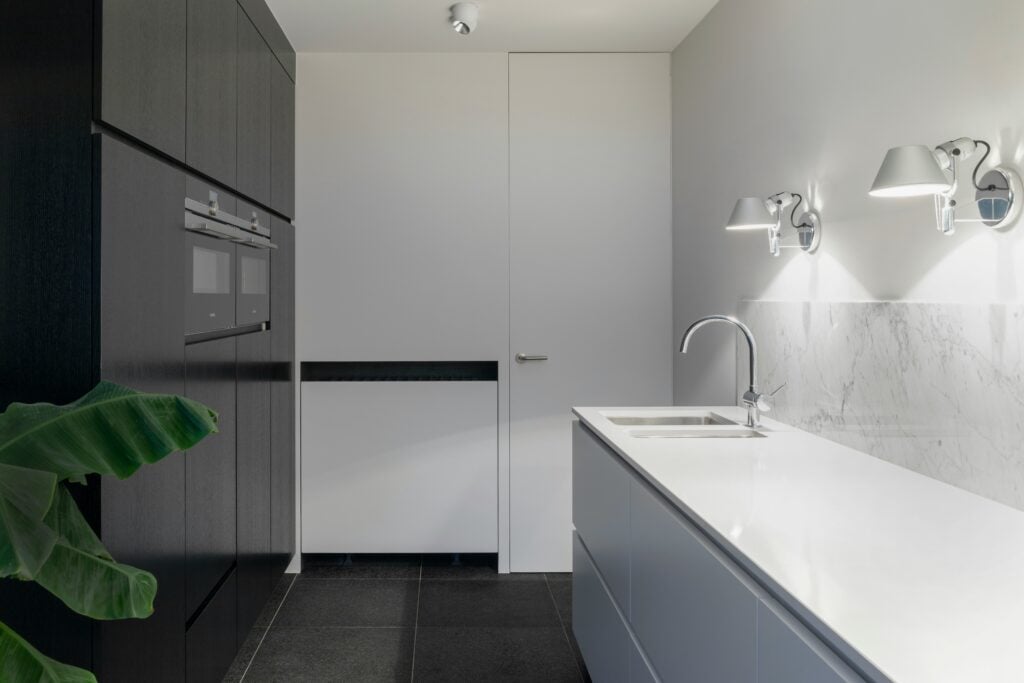 white stainless steel sink with faucet beside closed door